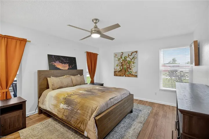Bedroom featuring wood finished floors, ceiling fan, and a textured ceiling