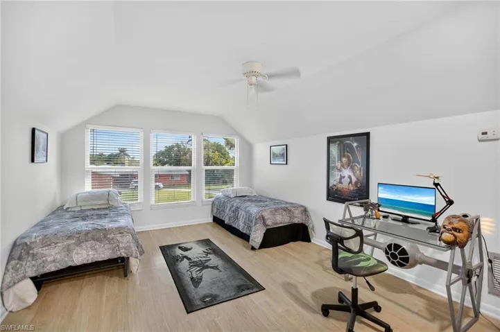 Bedroom featuring lofted ceiling, ceiling fan, and light wood finished floors