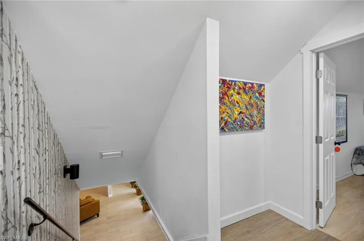 Staircase featuring wood finished floors and vaulted ceiling