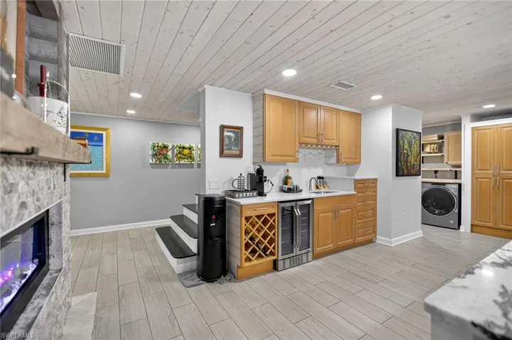 Bar area featuring wood ceiling, wood finish floors, washer / dryer, wine cooler, and recessed lighting