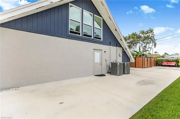 View of side of home with a central AC unit and stucco siding