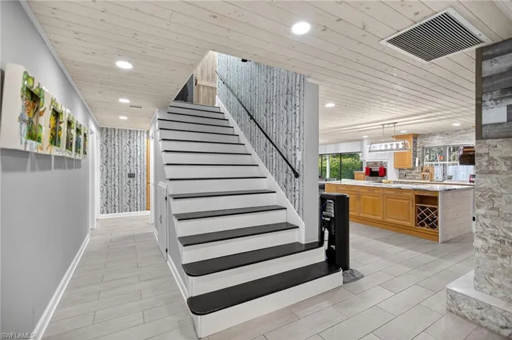 Stairway with wooden ceiling, recessed lighting, and wood tiled floors