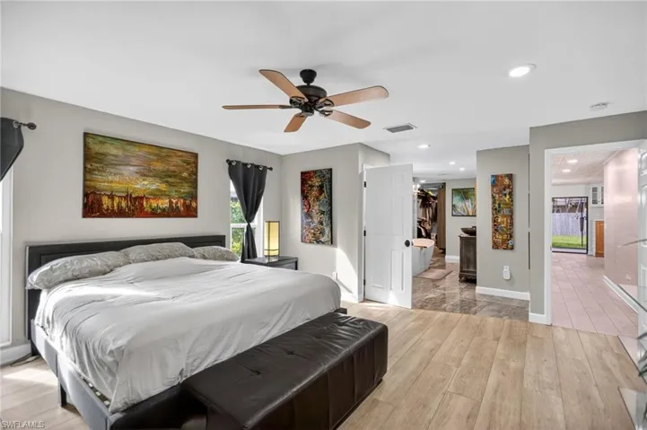Bedroom with light wood-style flooring, a spacious closet, recessed lighting, and ceiling fan