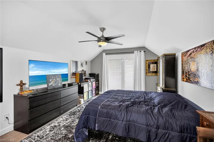 Bedroom featuring vaulted ceiling, a ceiling fan, and wood finished floors