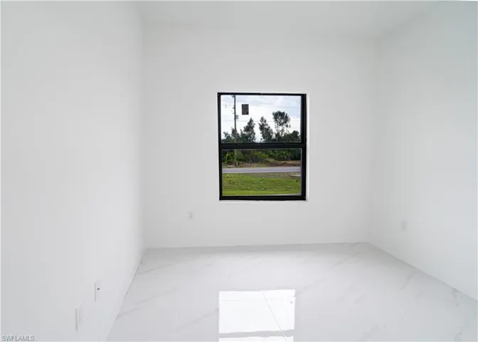 Empty room featuring marble finish flooring and baseboards