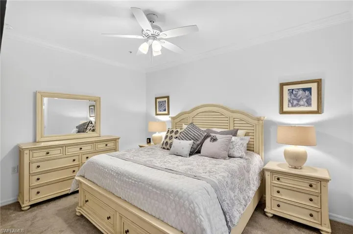 Bedroom featuring ornamental molding, carpet, and a ceiling fan