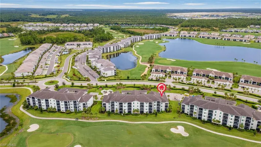 Aerial view of residential area with a golf course and a large body of water
