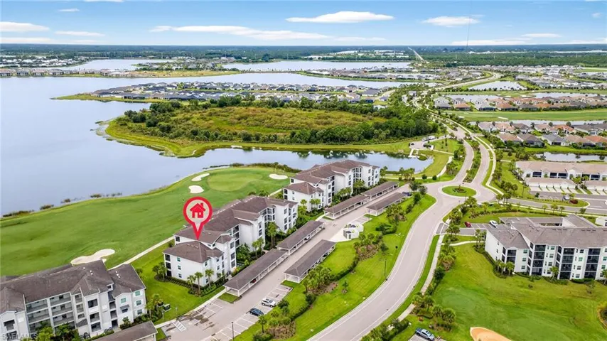 Aerial view of residential area with a local golf course and a large body of water