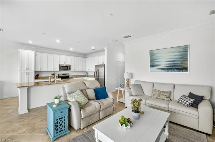 Living area featuring crown molding, recessed lighting, and light tile patterned floors