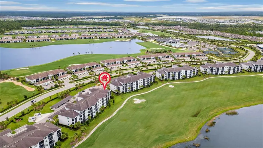 Aerial view of residential area with a local golf course and a large body of water