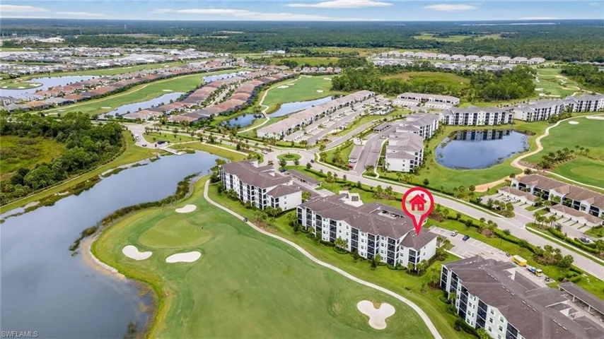 Aerial view of residential area with a golf club and a large body of water