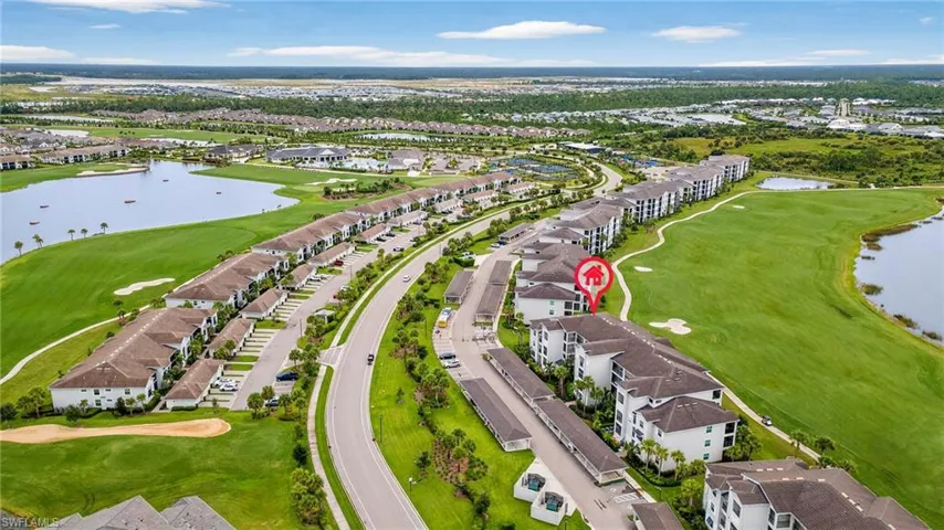 Aerial view of residential area with a nearby body of water and a golf course