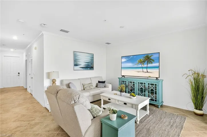 Living area with ornamental molding and light tile patterned floors