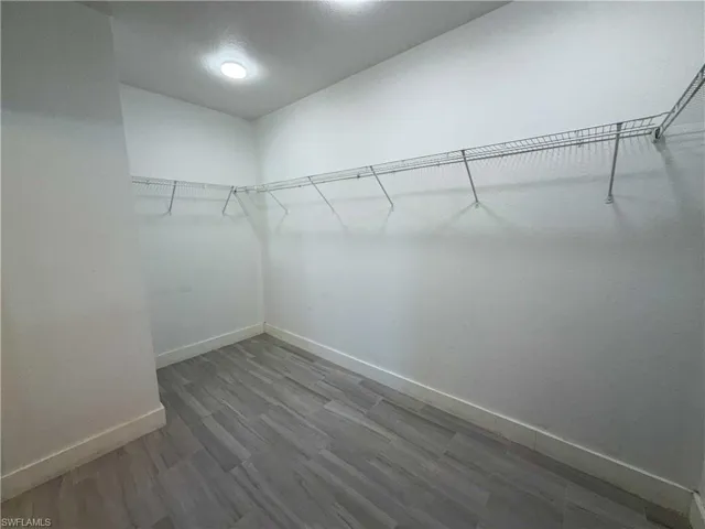 Walk in closet with wood finished floors