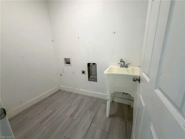 Laundry room with hookup for a washing machine, light wood-style flooring, and electric dryer hookup