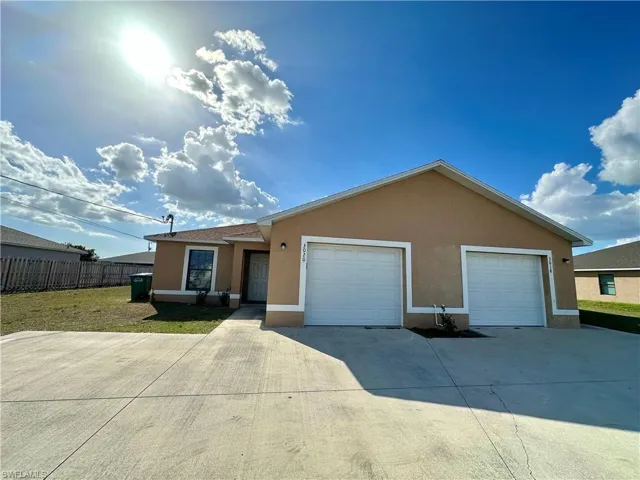 Ranch-style house featuring stucco siding, driveway, and a garage