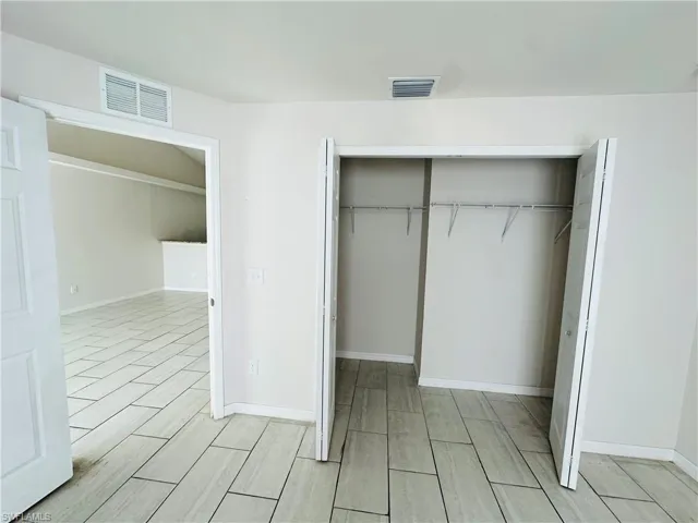 Unfurnished bedroom with wood tiled floors and a closet
