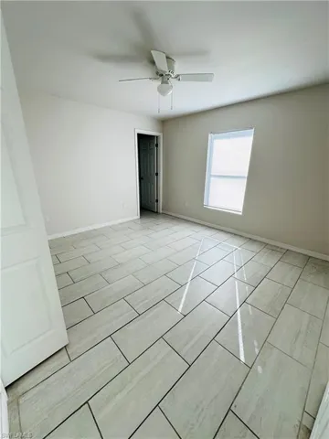 Unfurnished room with baseboards and ceiling fan