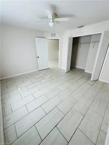 Unfurnished bedroom featuring ceiling fan and a closet