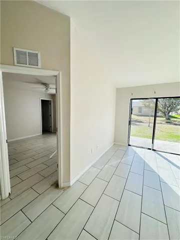 Unfurnished room with vaulted ceiling, wood tiled floors, and a ceiling fan