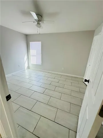 Spare room with baseboards and a ceiling fan