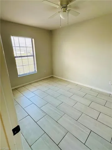Empty room with a ceiling fan and wood finish floors