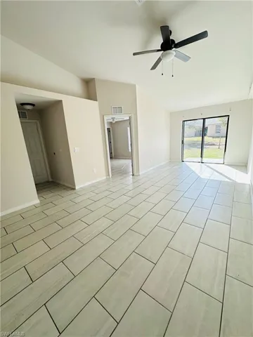 Spare room featuring lofted ceiling and a ceiling fan