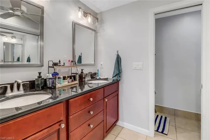 Bathroom with vanity, tile patterned floors, and ceiling fan