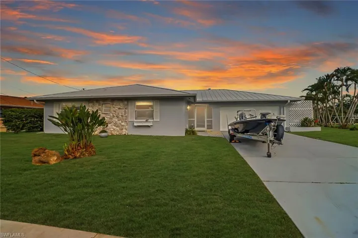 View of front facade featuring a garage and a lawn