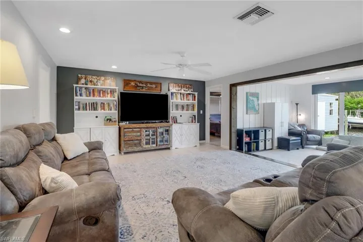 Tiled living room with built in features and ceiling fan