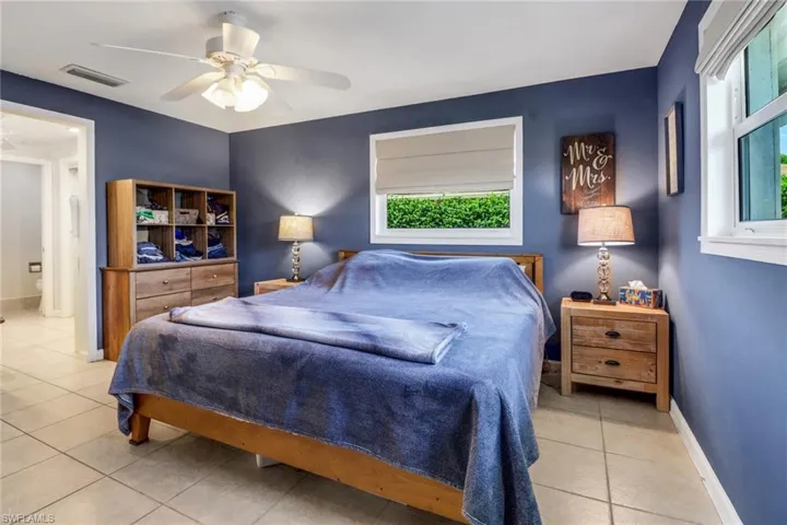 Bedroom with light tile patterned flooring and ceiling fan