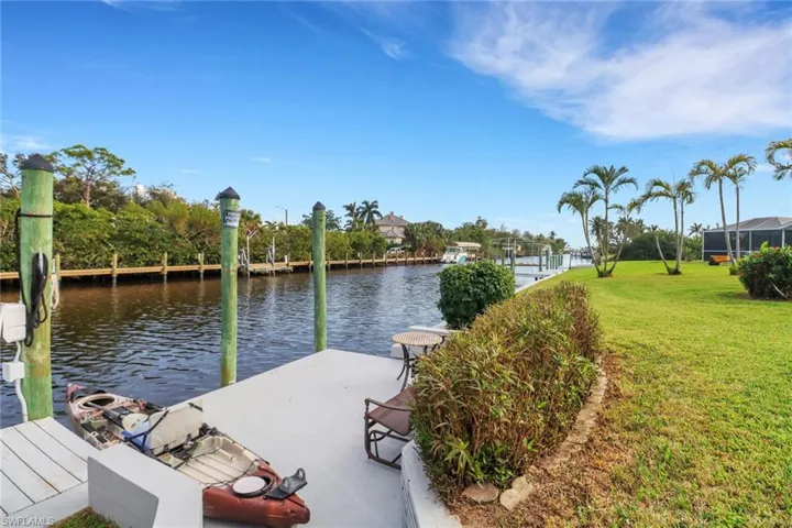 Dock area with a water view and a yard
