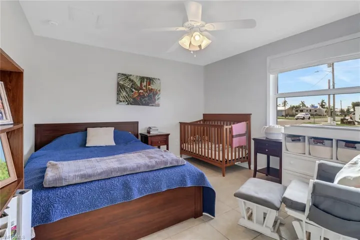 Tiled bedroom featuring ceiling fan