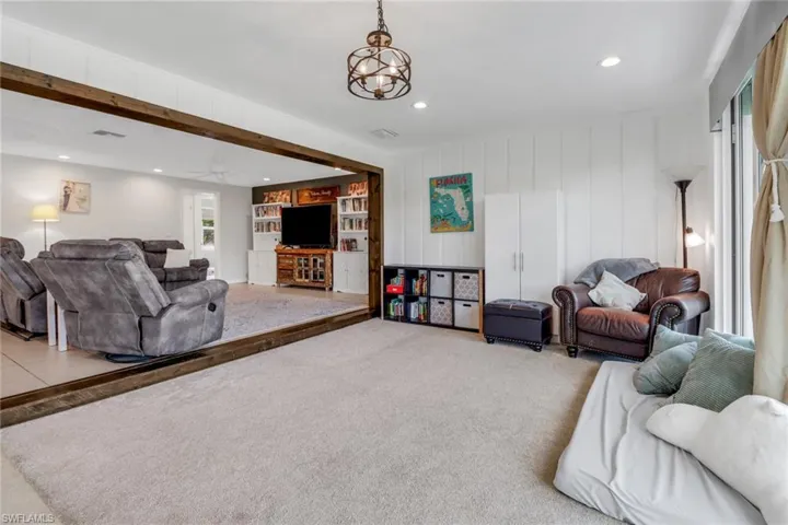 Living room featuring carpet floors and a notable chandelier