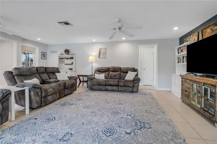 Tiled living room featuring ceiling fan