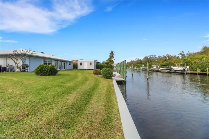 View of yard with a dock and a water view
