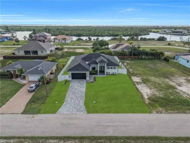 Modern exterior with a dark shingle roof, paver driveway, and an attached garage