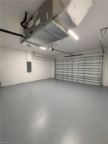 Garage featuring electric panel and a garage door opener