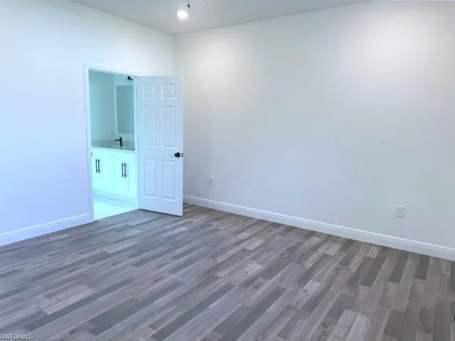 Unfurnished room featuring wood finished floors and baseboards