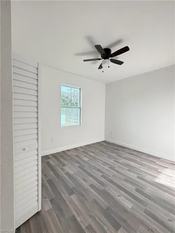 Unfurnished bedroom with wood finished floors and a ceiling fan