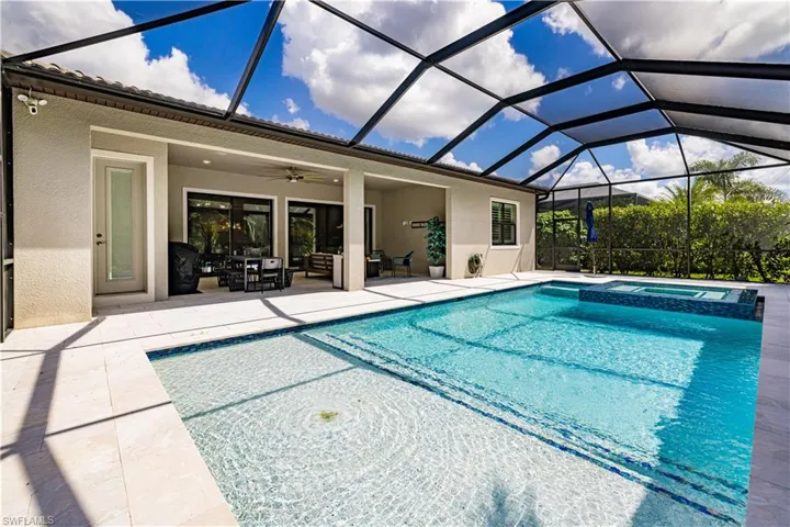 View of swimming pool featuring ceiling fan, a sunroom, glass enclosure, and a patio area