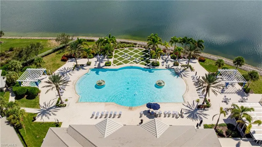 Drone / aerial view of a pool area and a nearby body of water