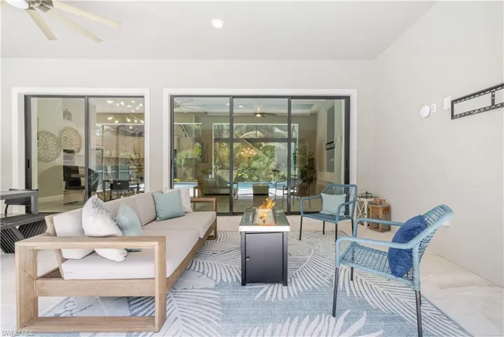 View of patio with a ceiling fan and an outdoor living space with a fire pit