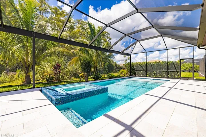 View of swimming pool with a sunroom, a pool with connected hot tub, a lanai, and a patio area