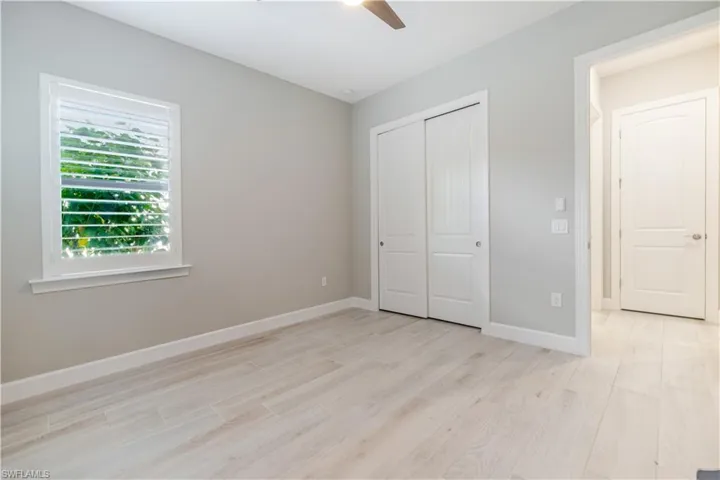 Unfurnished bedroom featuring light wood-style flooring, a ceiling fan, and a closet