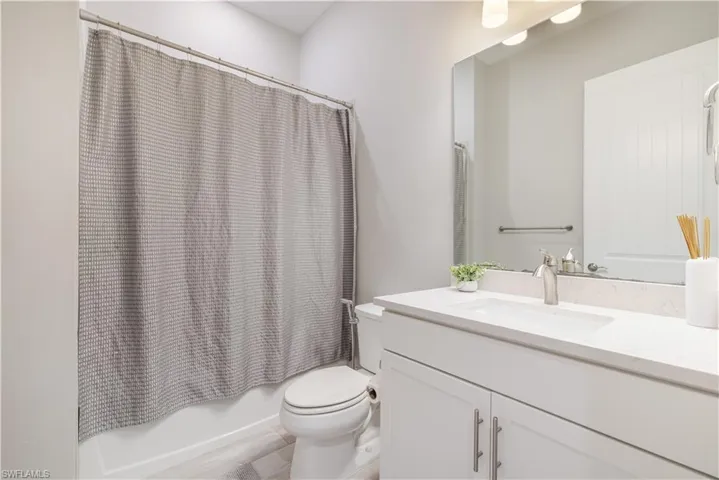 Bathroom featuring shower / bath combination with curtain and vanity