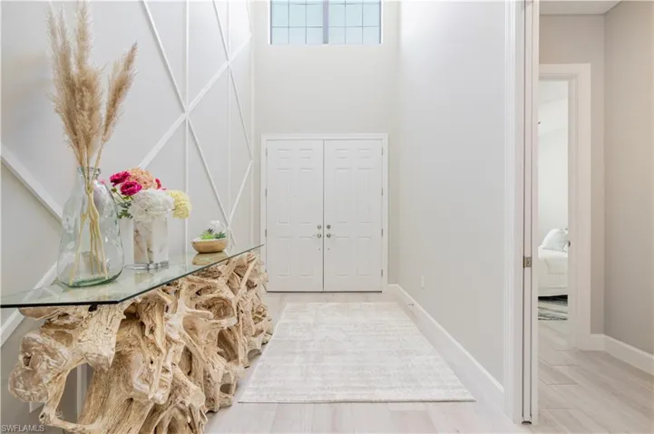 Foyer entrance featuring wood finished floors and a towering ceiling