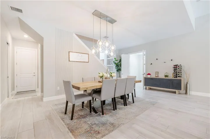 Dining area with light wood-style floors, recessed lighting, and a chandelier