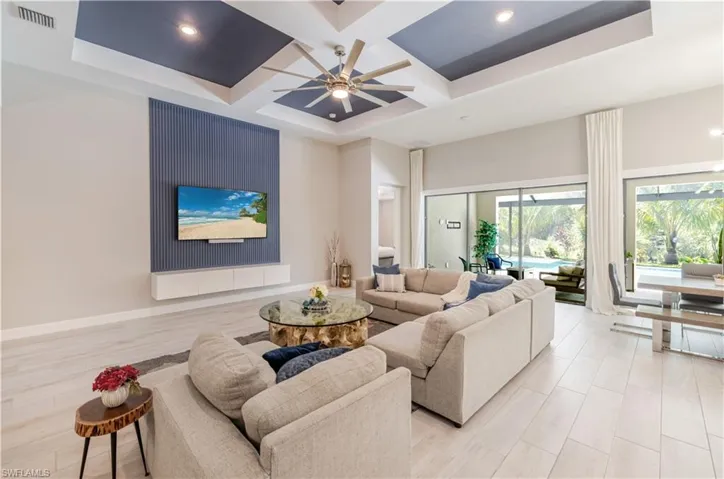 Living area with coffered ceiling, light wood-type flooring, beamed ceiling, ceiling fan, and recessed lighting