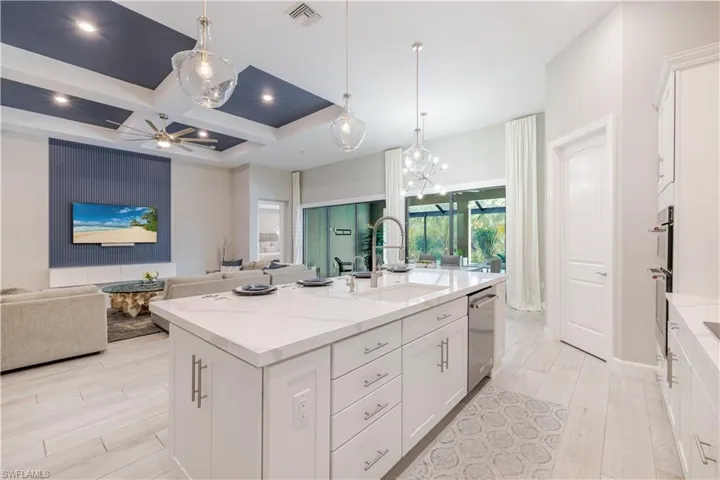 Full bath featuring vanity, light wood-style flooring, coffered ceiling, beamed ceiling, and a chandelier